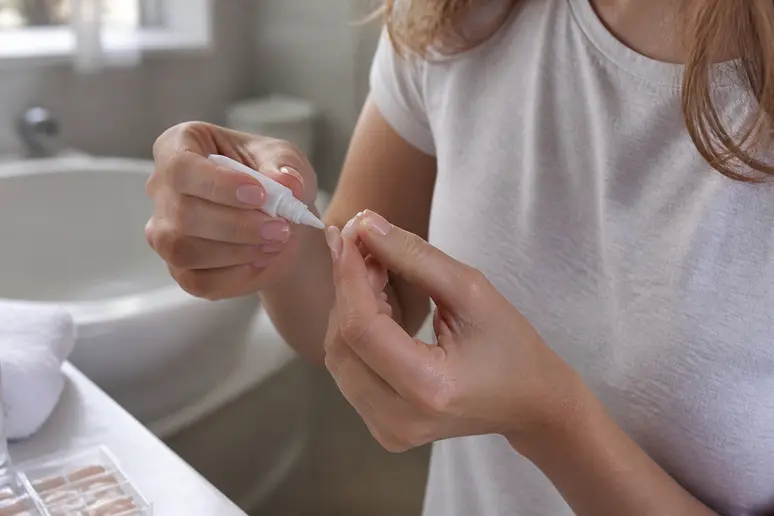 Application soignée de colle liquide pour comment coller des faux ongles sur un ongle naturel.