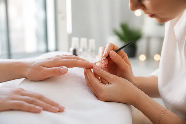 Technicienne appliquant un gainage ongle c'est quoi dans un salon lumineux.