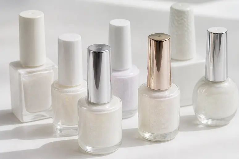 Gamme de vernis semi-permanents blancs nacrés de différentes marques, affichant des prix abordables.