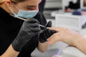 Technicienne experte en formation manucure russe avec outils précis pour cuticules.