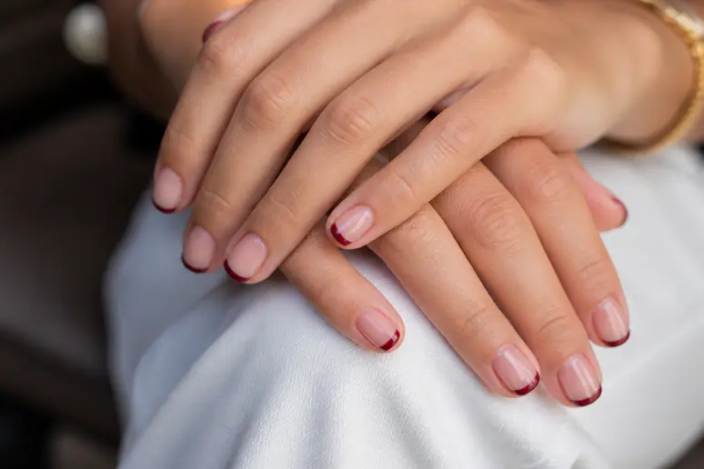 French manucure bordeaux fine et élégante réalisée sur des ongles courts