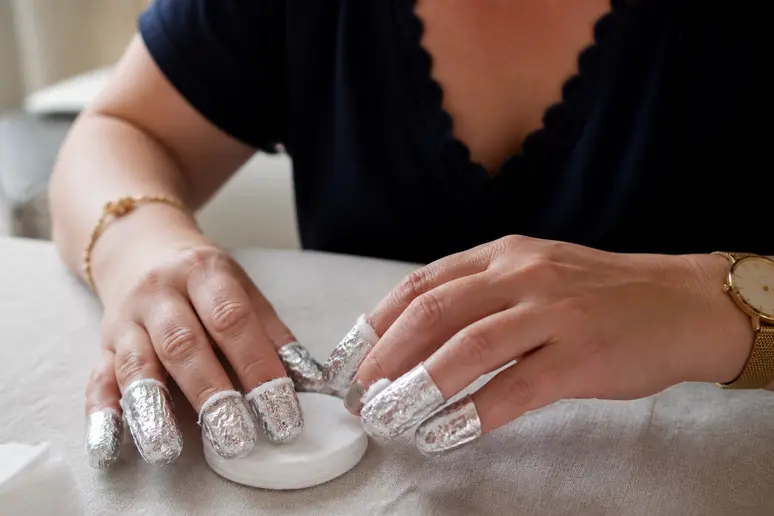 Manucure hiver : mains préparant la dépose du vernis semi-permanent avec des papillotes d'acétone.
