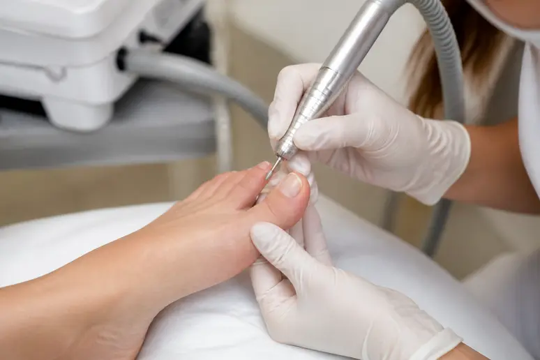 Préparation minutieuse à sec du contour de l'ongle lors d'une manucure russe pied