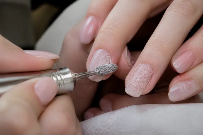 Risques de manucure tendance 2026: dépose de semi-permanent avec risque de ponçage excessif de l'ongle.