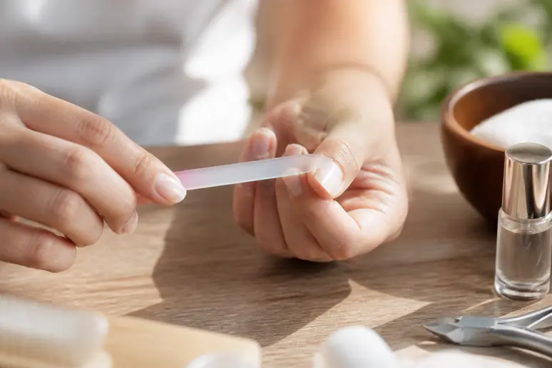 Limage minutieux d'ongles courts naturels avec une lime pour préparer une manucure propre