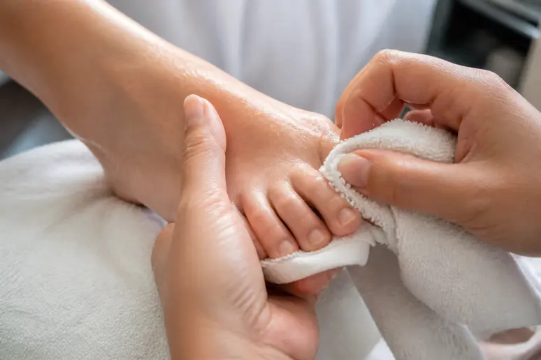 Séchage minutieux des pieds entre les orteils pour prévenir un ongle de pied noir sans choc dû aux mycoses.