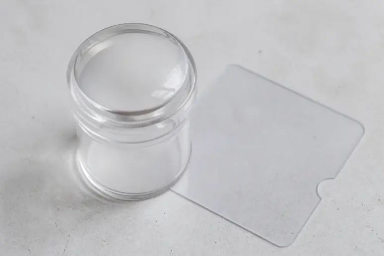 Tampon en silicone transparent et raclette pour stamping nail art, outils indispensables.