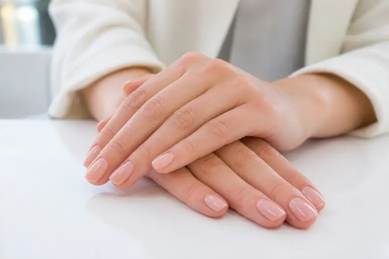 Mains soignées présentant une manucure élégante et des ongles parfaitement entretenus.