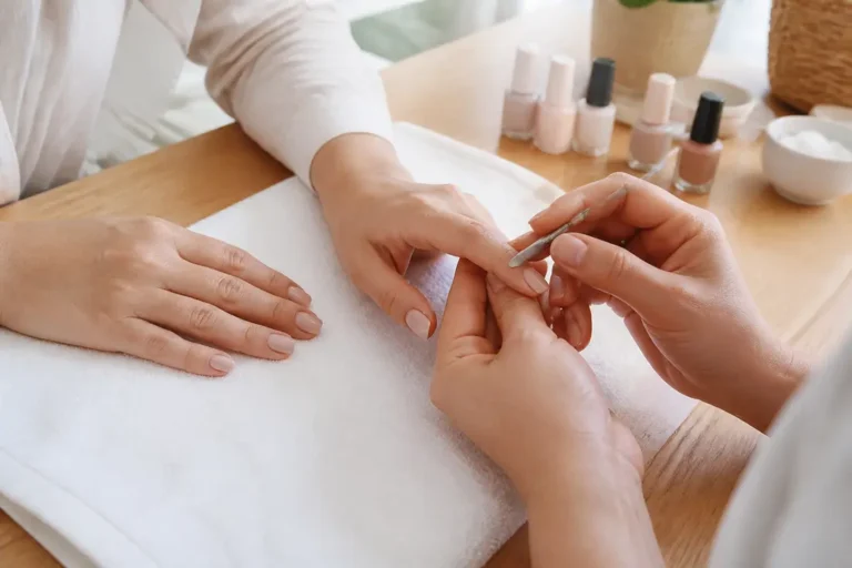 Une esthéticienne réalise une prestation soignée lors d'une séance de manicure ou manucure en salon.