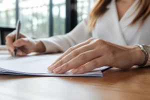 Mains soignées présentant un nail art discret chic sur ongles courts dans un bureau lumineux