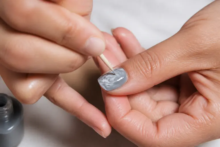 Réalisation d'un nail art effet marbre avec un cure-dent sur une base claire
